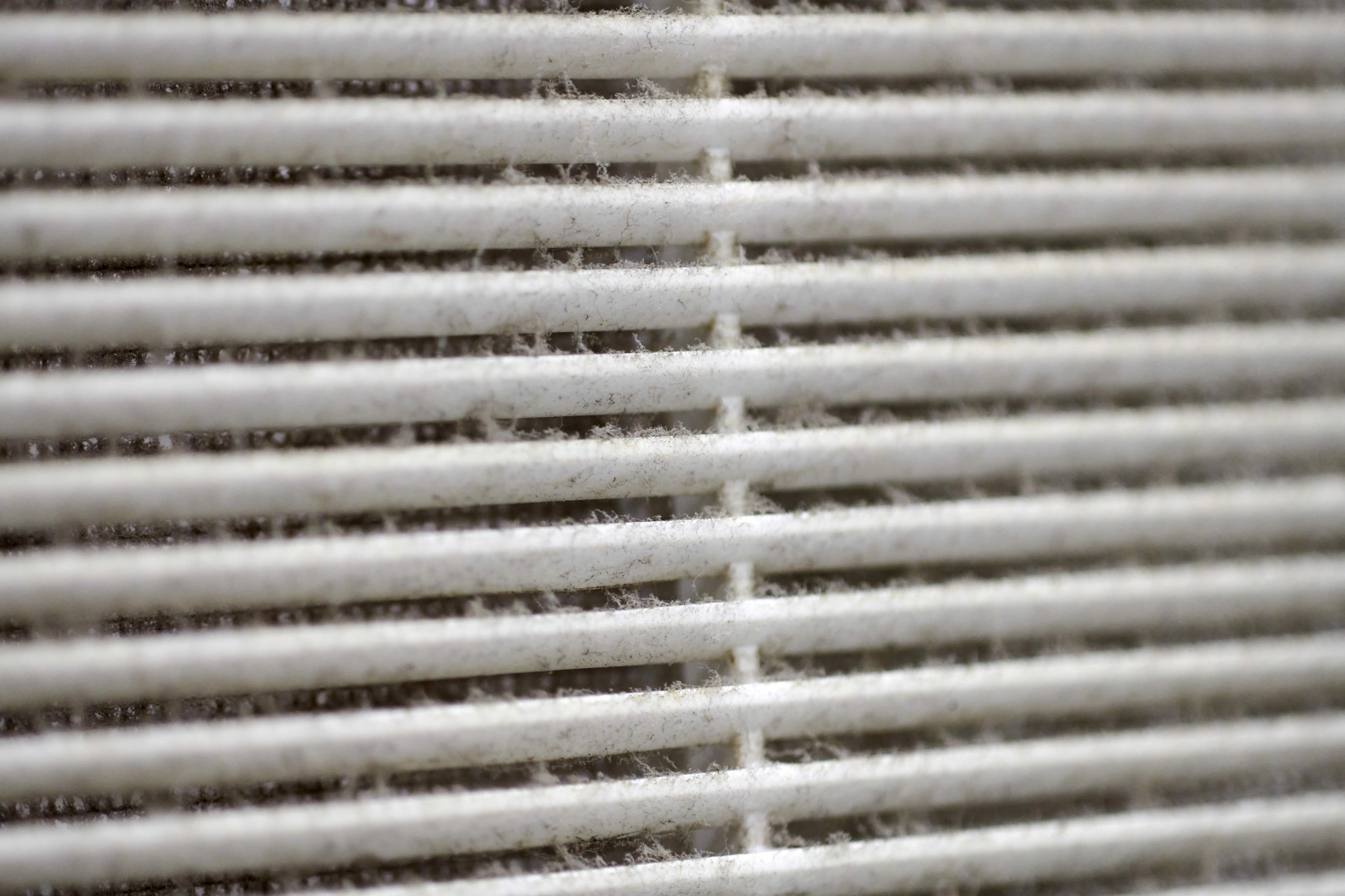 A dusty air vent grille showing the need for professional air filtration in Phoenix.
