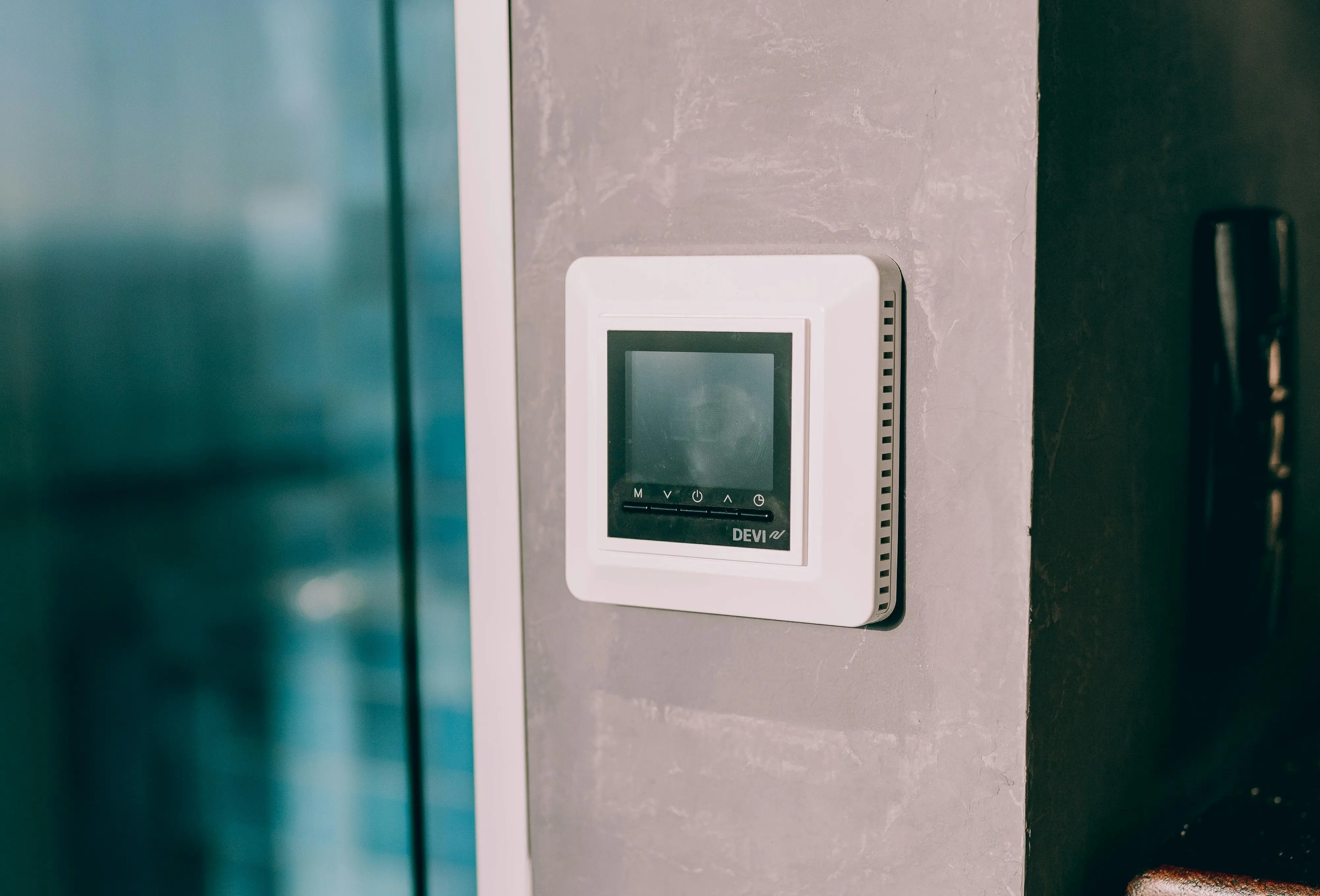Professional installation of a digital wall-mounted thermostat by AC by Sam LLC.